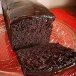 Schokoladenkuchen mit glänzender Glasur und frischen Beeren dekoriert