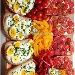 Brot mit Butter,Tomate und Ei auf einem Teller serviert