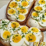 Brot mit Ei und frischem Schnittlauch auf einem Teller