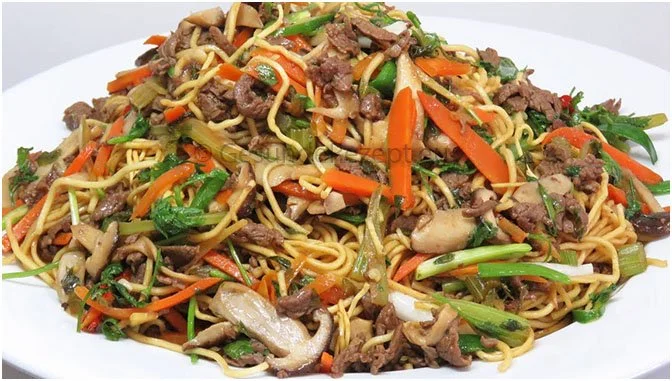 Chinesisch gebratene Nudeln mit Hühnchen, Ei und Gemüse auf einem Teller