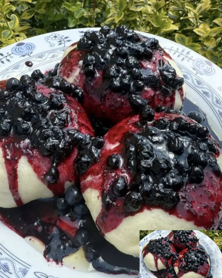 Dampfnudeln mit Heidelbeer-Soße serviert auf einem Teller