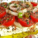 Gebackener Schafskäse, serviert mit frischen Kräutern und Olivenöl