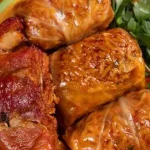 Geschmorte Kohlrouladen mit Fleischfüllung auf einem Teller serviert.