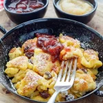 Traditioneller Kaiserschmarrn serviert mit Apfelmus auf einer Ski-Hütte.