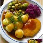 Knuspriges Schnitzel mit Beilagen von Rosenkohl, Rotkohl und Kartoffelklößen