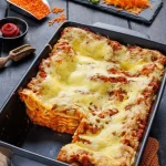 Linsenlasagne mit roten Linsen auf einem Teller serviert