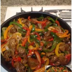 Rindfleisch mit Paprika und Zwiebeln auf einem Teller serviert