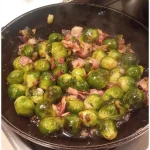 Rosenkohl mit Speck und Zwiebeln in brauner Butter auf einem Teller