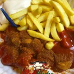 Selbstgemachte Currywurst mit Pommes - ein klassisches deutsches Gericht
