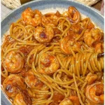 Spaghetti mit Garnelen und Tomatensauce serviert auf einem Teller