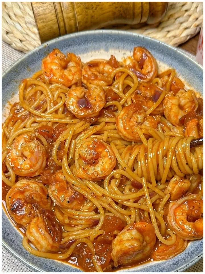 Spaghetti mit Garnelen und Tomatensauce serviert auf einem Teller