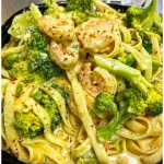 Tagliatelle mit Brokkoli und Garnelen in cremiger Sauce serviert in einem weißen Teller.