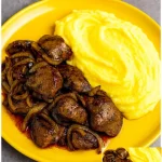 Hühnerleber mit Kartoffelpüree auf einem Teller serviert