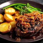 Zwiebelrostbraten mit Zwiebeln und Beilagen, traditionelles deutsches Gericht