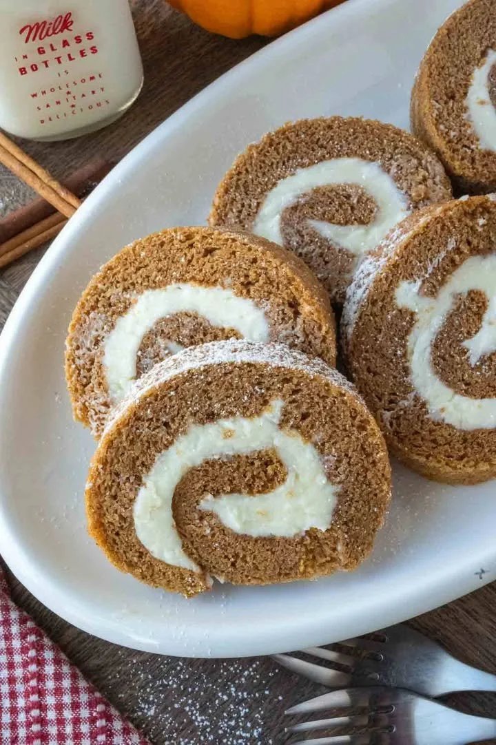 Köstliche Kürbisrolle auf einem Teller, dekoriert mit Zimt und Nüssen