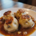 Hausgemachte Leberknödel serviert mit Beilagen und Soße