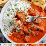 Hähnchen Tikka Masala mit Reis und frischen Kräutern serviert