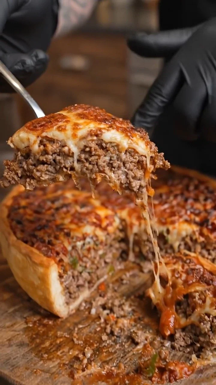 Hausgemachte Chicago-Style Deep-Dish Rindfleischpizza auf einem Holzbrett