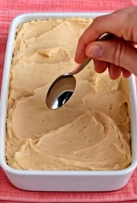 Tasse Mokka-Creme mit Sahne und Kaffeebohnen auf einem Tisch